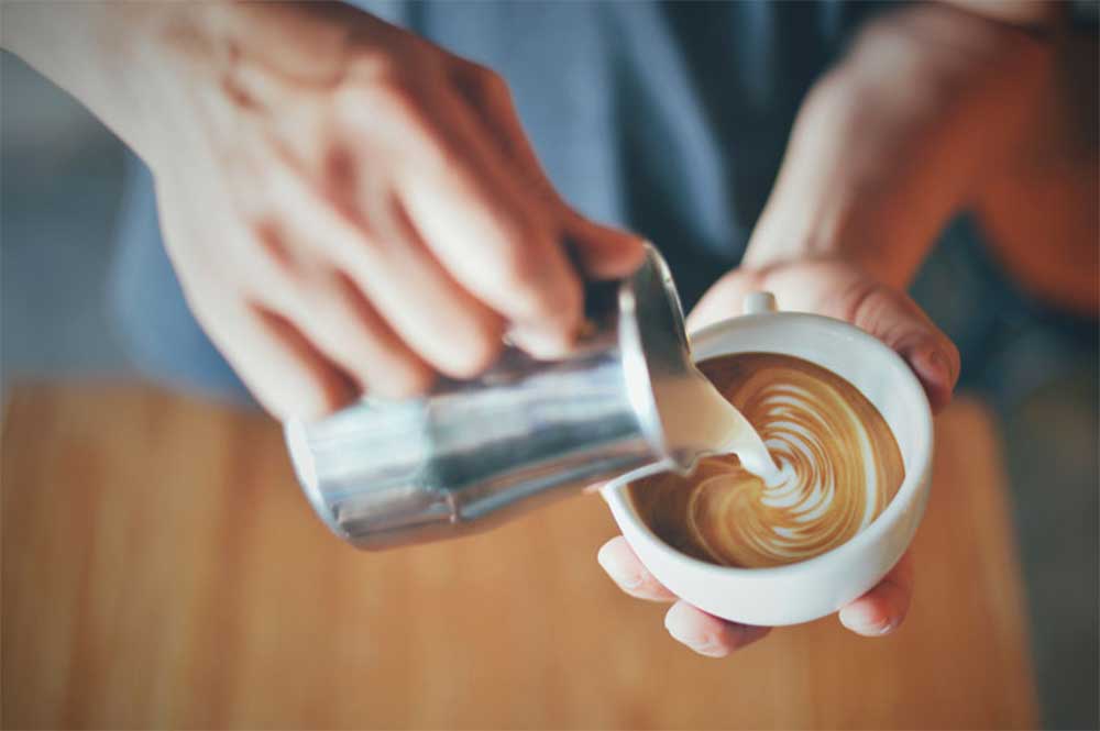 Mjölk som hälls upp i kaffe